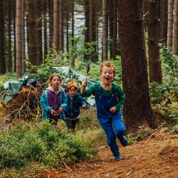 Children running and playing in the woodland