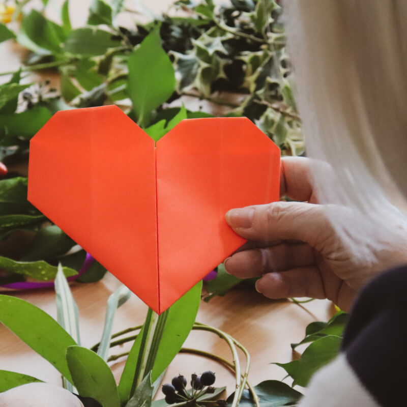 A red paper heart shape. Crafts are a feature of Wild at Heart Sessions